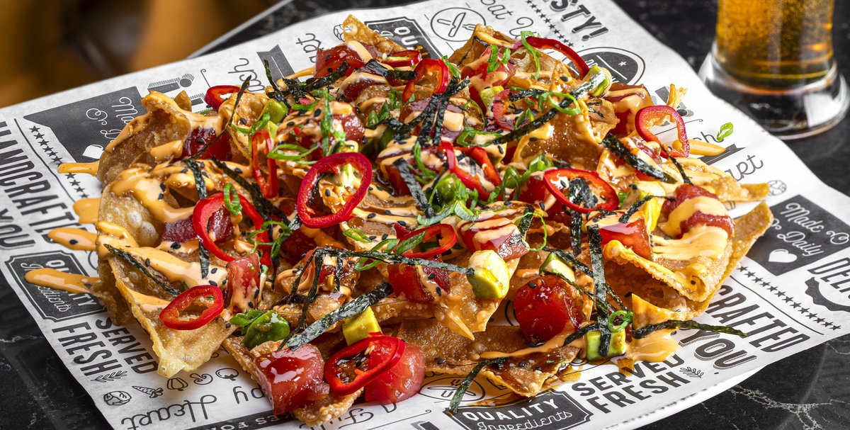 Poke nachos topped with tuna, sliced red chiles and spicy mayo on printed paper at Render Modern Kitchen (venue photo by Chris Wessling)