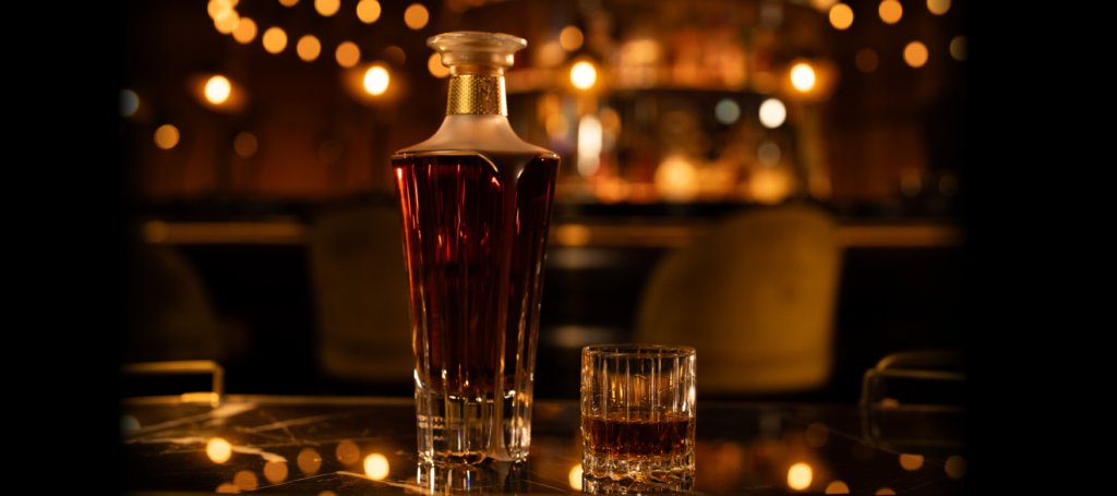 Crystal decanter of Midleton whiskey next to a short pour in a cut-glass tumbler on a dark marble bar (venue graphic)
