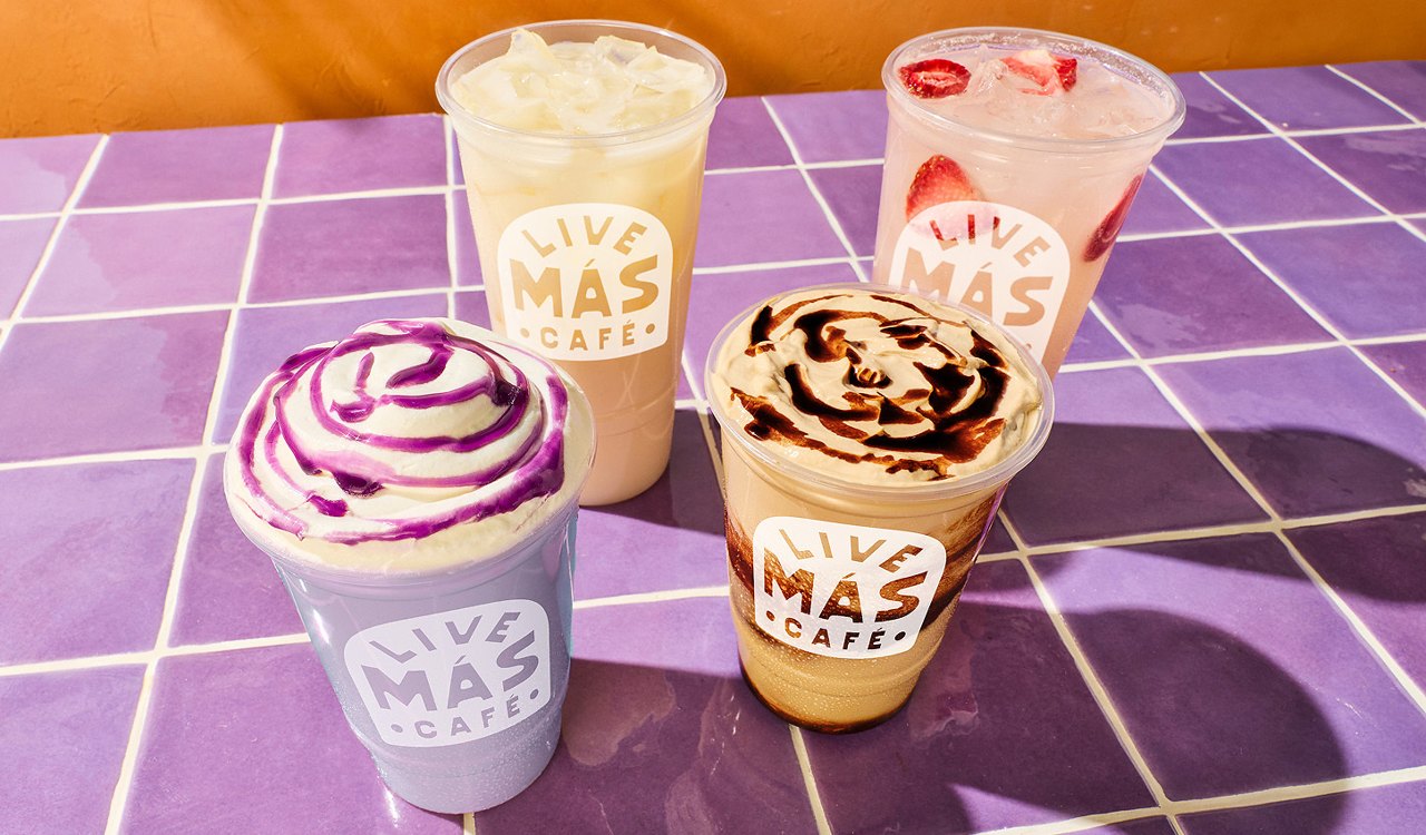 Four Live Más Café horchata drinks, one swirled with purple and one with chocolate, on a purple tile table (Taco Bell press photo)