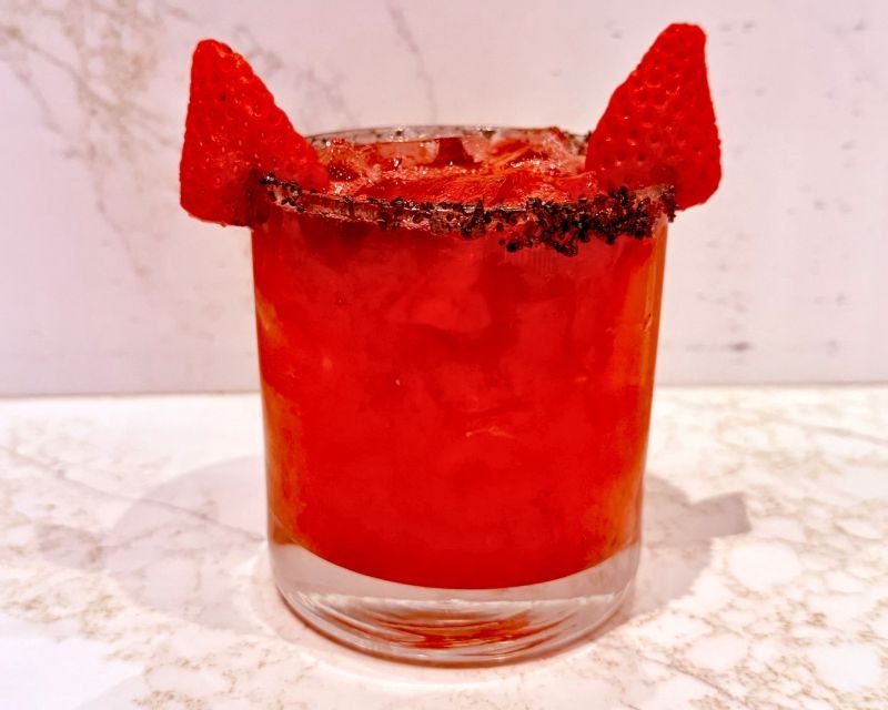A red Strawberry Devil Margarita with a salted rim and two strawberry horns (America Restaurant & Bar photo)