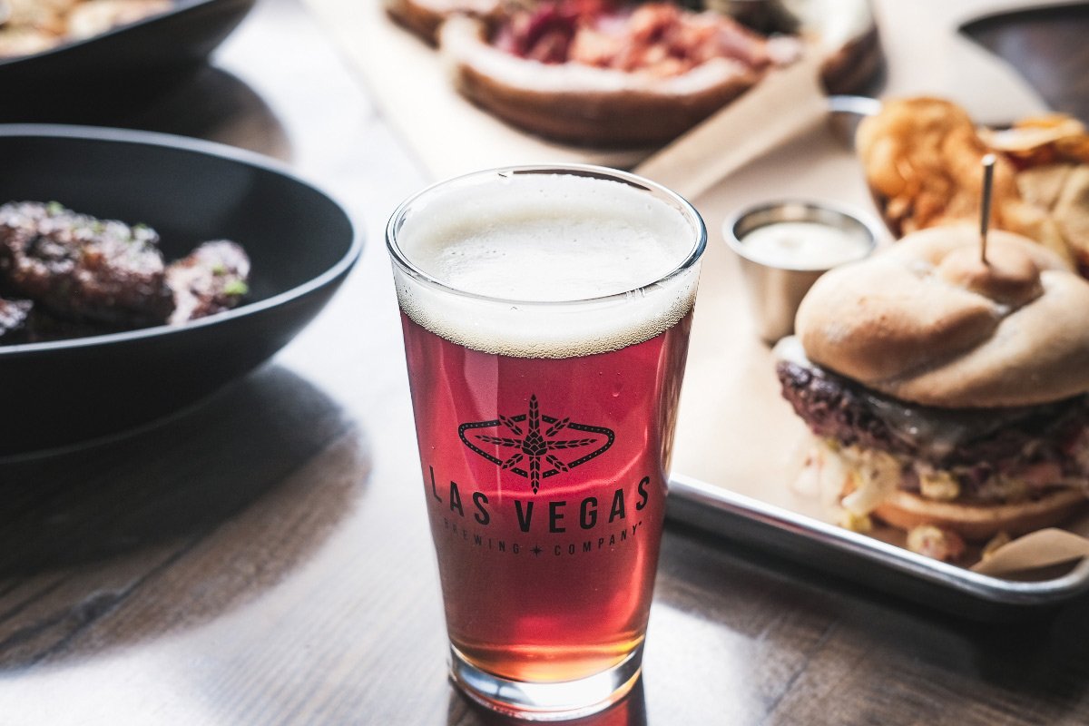 A pint of red beer in a Las Vegas Brewing Company glass next to a burger and sides (Las Vegas Brewing Company photo)