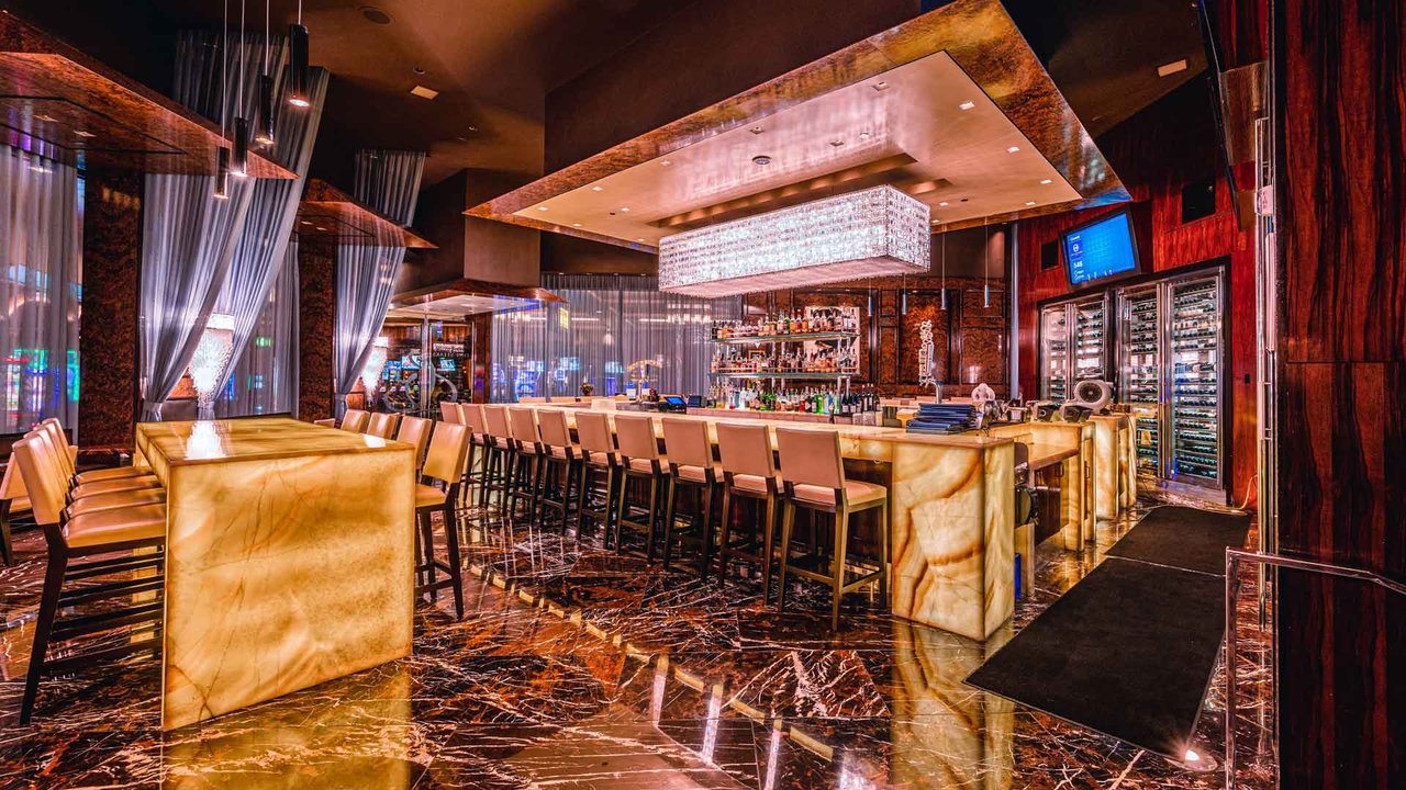 Hank's backlit bar with a row of empty stools and dark wood (Hank's photo)