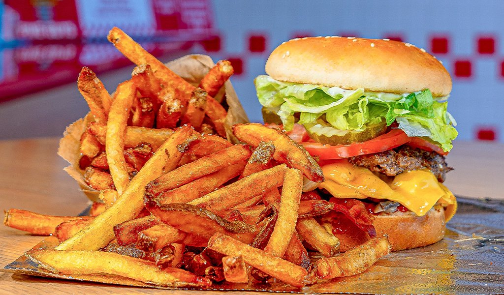 A Five Guys cheeseburger with lettuce and tomato next to a pile of fries on foil (Plaza Hotel & Casino photo)