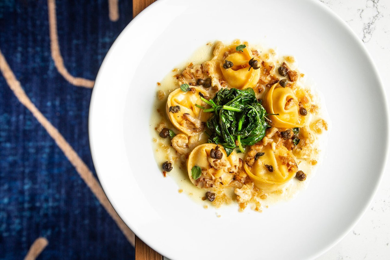 A plate of Brezza's cappellacci pasta with greens on a white plate (Resorts World Las Vegas photo)
