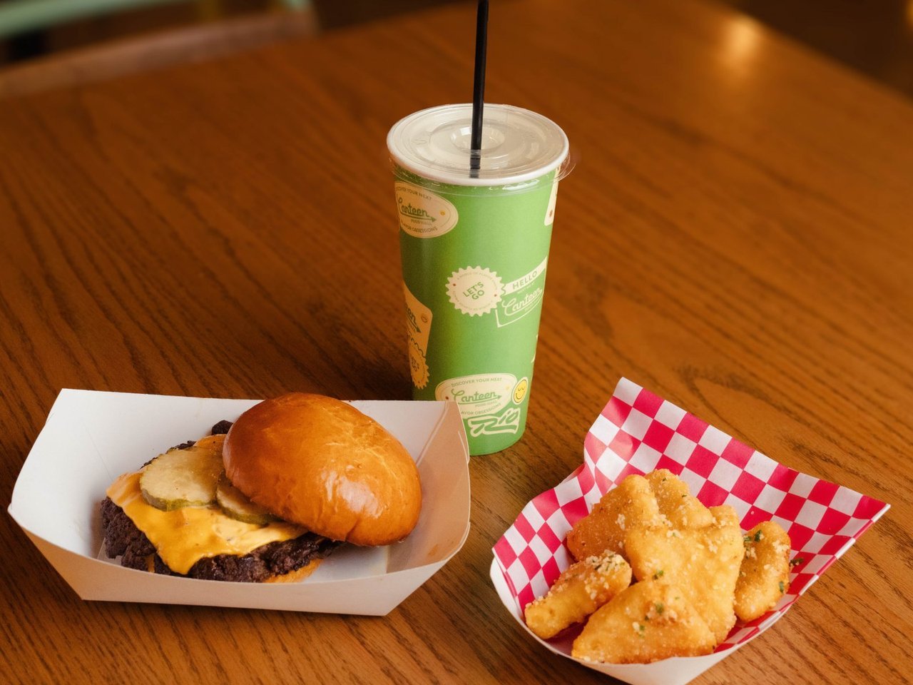 A Stack'd smashed burger with fries and a drink on a wooden table (Rio Las Vegas photo)